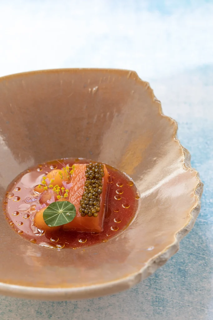 Osietra Premium Gold Kaviar auf Lachstatar mit Melone und Jus. Serviert in schicker Schale